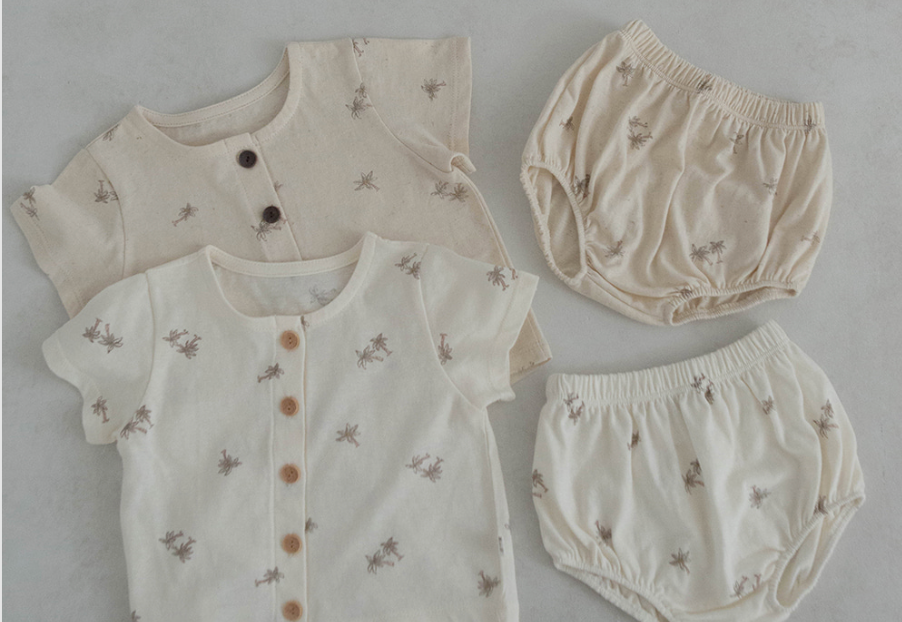 light oatmeal colored cotton baby tshirt and bloomer set adorned with wooden buttons and palm tree decals