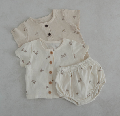 light oatmeal colored cotton baby tshirt and bloomer set adorned with wooden buttons and palm tree decals